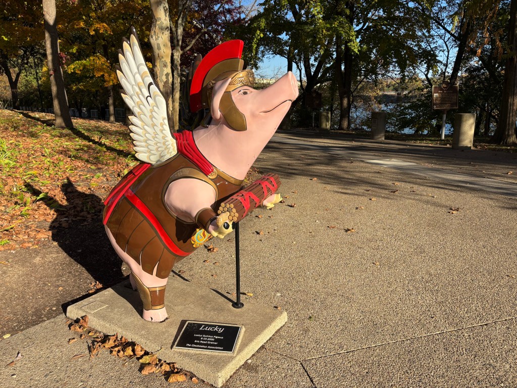 A fiberglass statute of a winged pig, named "Lucky," styled after a classic Roman soldier who is bearing the fasces.